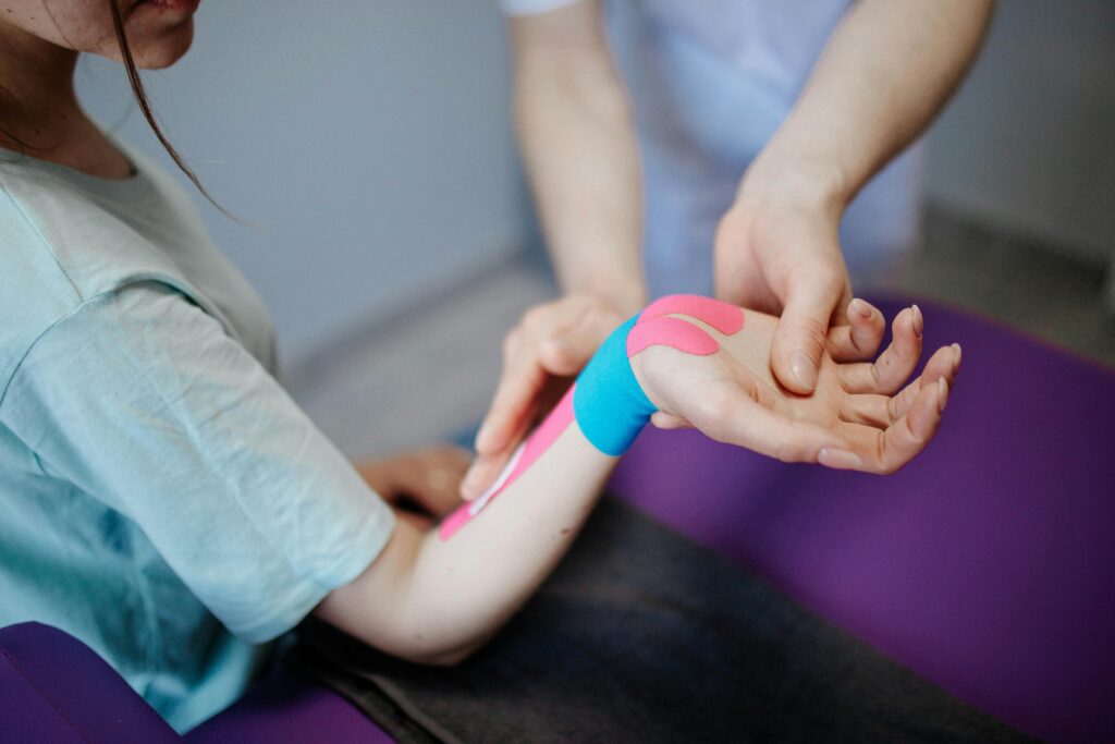 Bei einer Patientin wird Kinesio-Taping nach einer Verletzung oder Operation gemacht